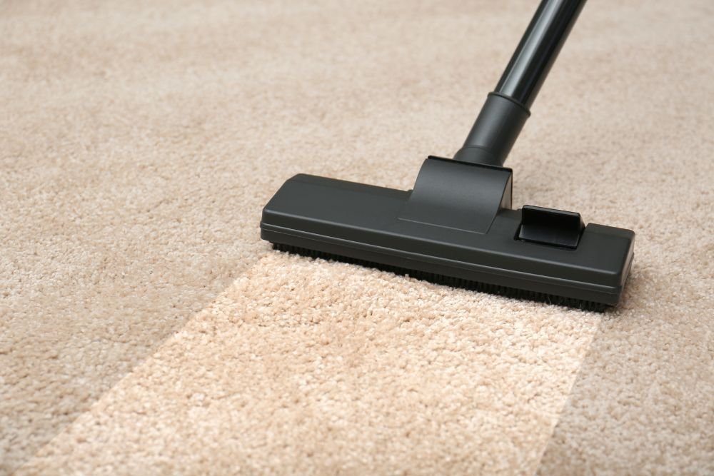 A vacuum cleaner working on a carpet, showcasing a carpet cleaning service located in Columbia, SC.